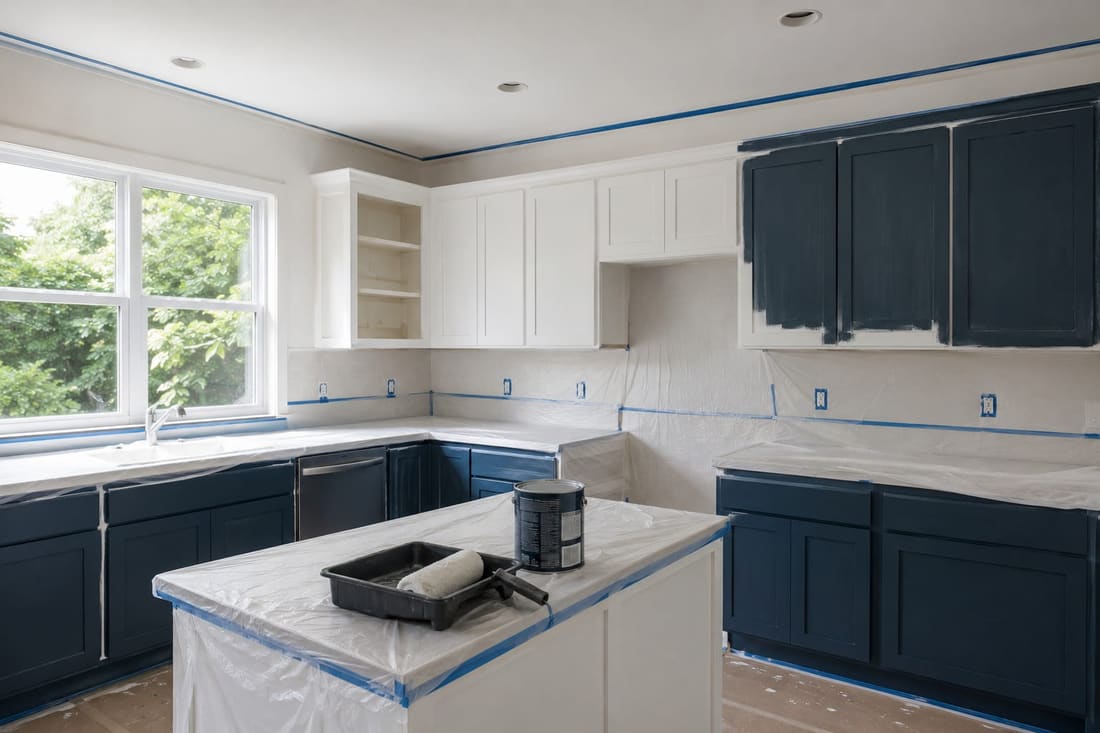 Interior painter preparing a Wellington kitchen with masking tape and drop sheets